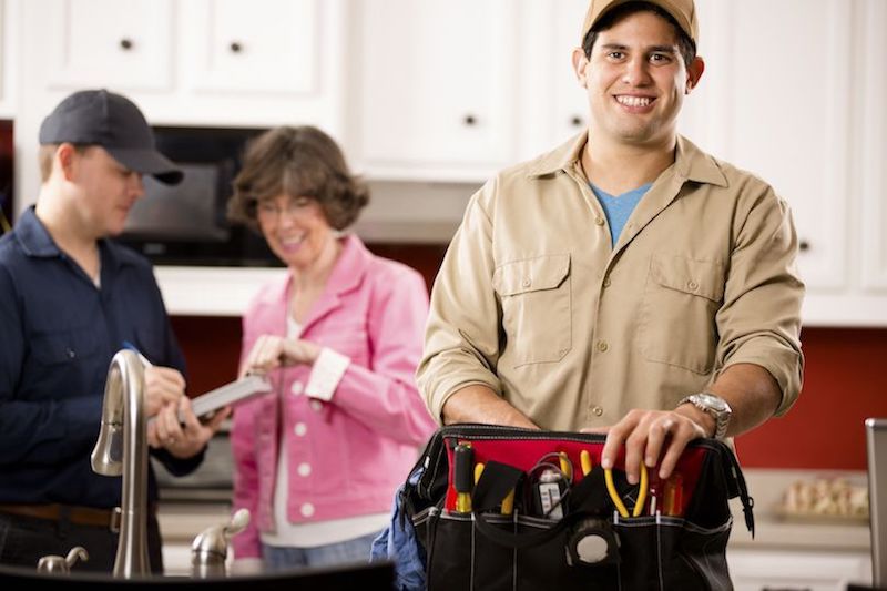 HVAC technician smiling holding tools