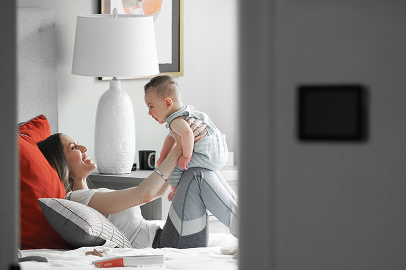 Mother and baby playing on bed