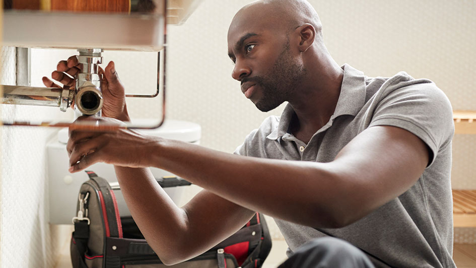 Man working on a sink drain