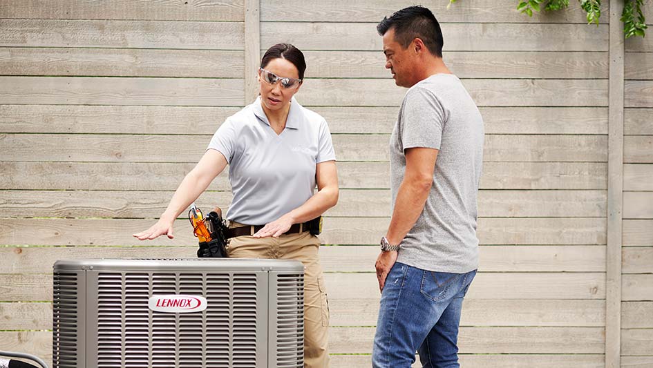 Technician showing a man an air conditioning unit