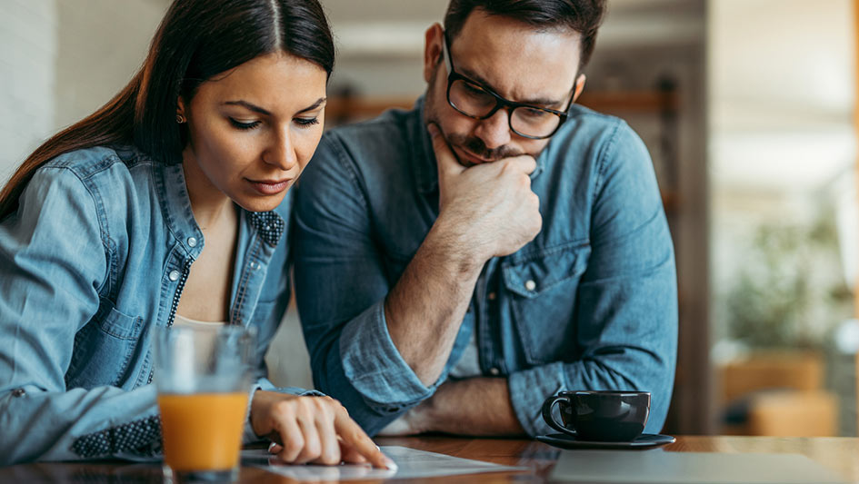 Couple looking at a piece of paper on a table