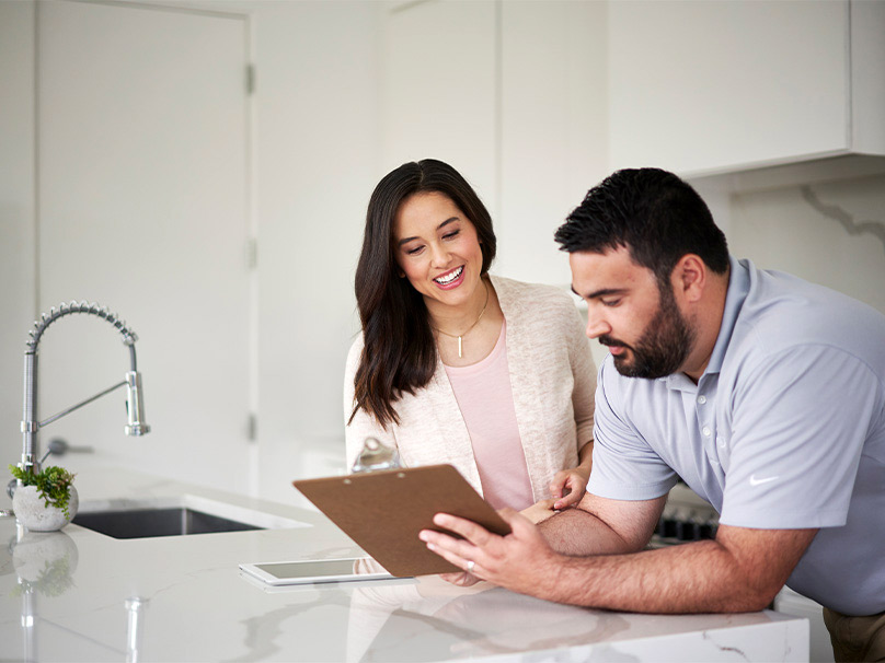 Man showing a woman a clip board