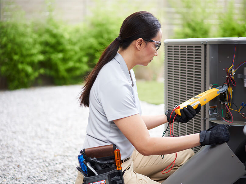 Woman repairing a heat pump