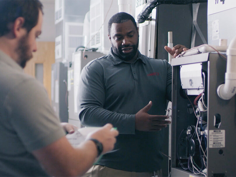 HVAC technicians discussing a furnace