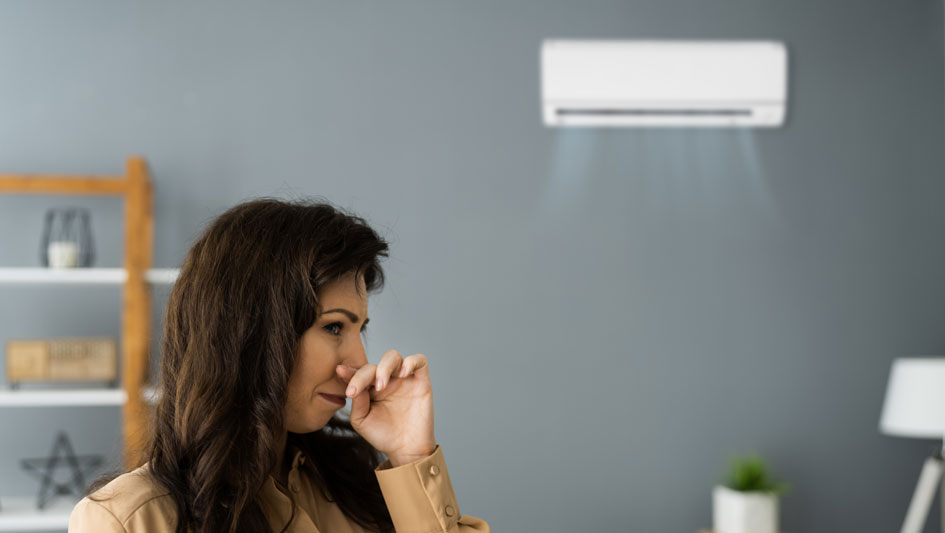 woman smelling air from a mini split unit