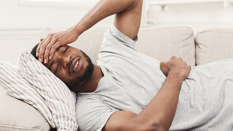 man laying on the couch sick