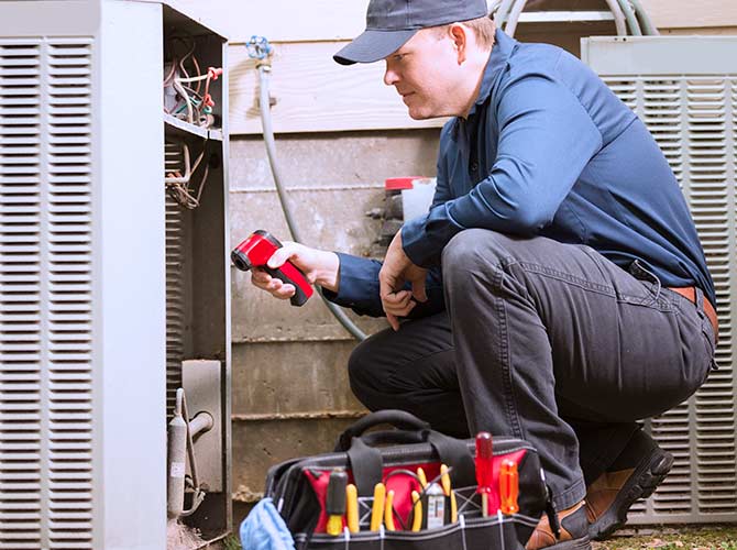 HVAC technician performing AC maintenance