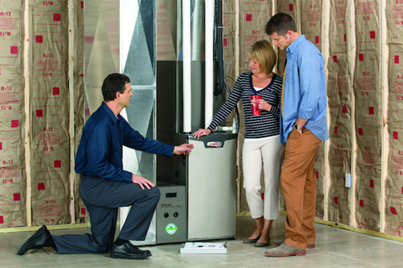 HVAc technician talking with a couple near their furnace