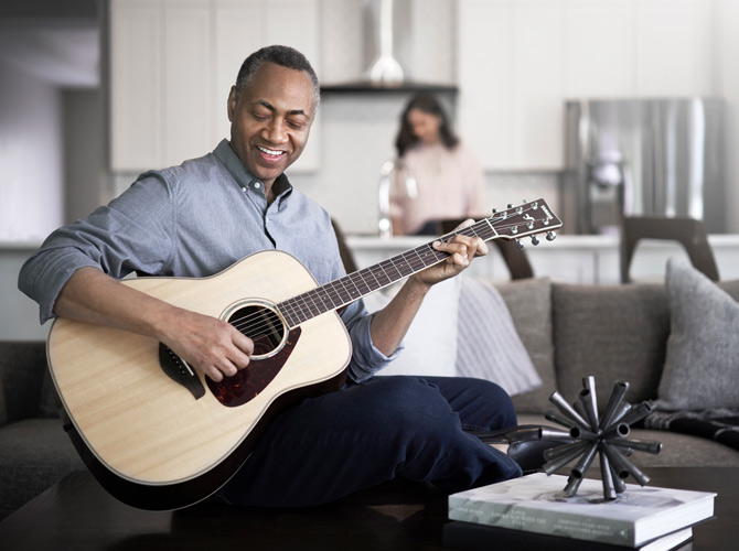man playing guitar on the couch