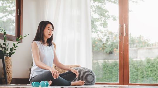 Woman in meditative pose indoors