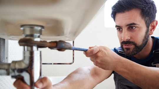 Plumbing technician repairing sink
