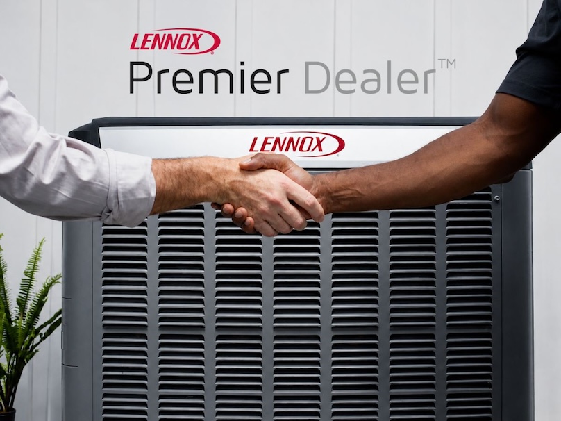 Close in of two men shaking hands in front of a Lennox air conditioner with the Lennox Premier Dealer logo above it